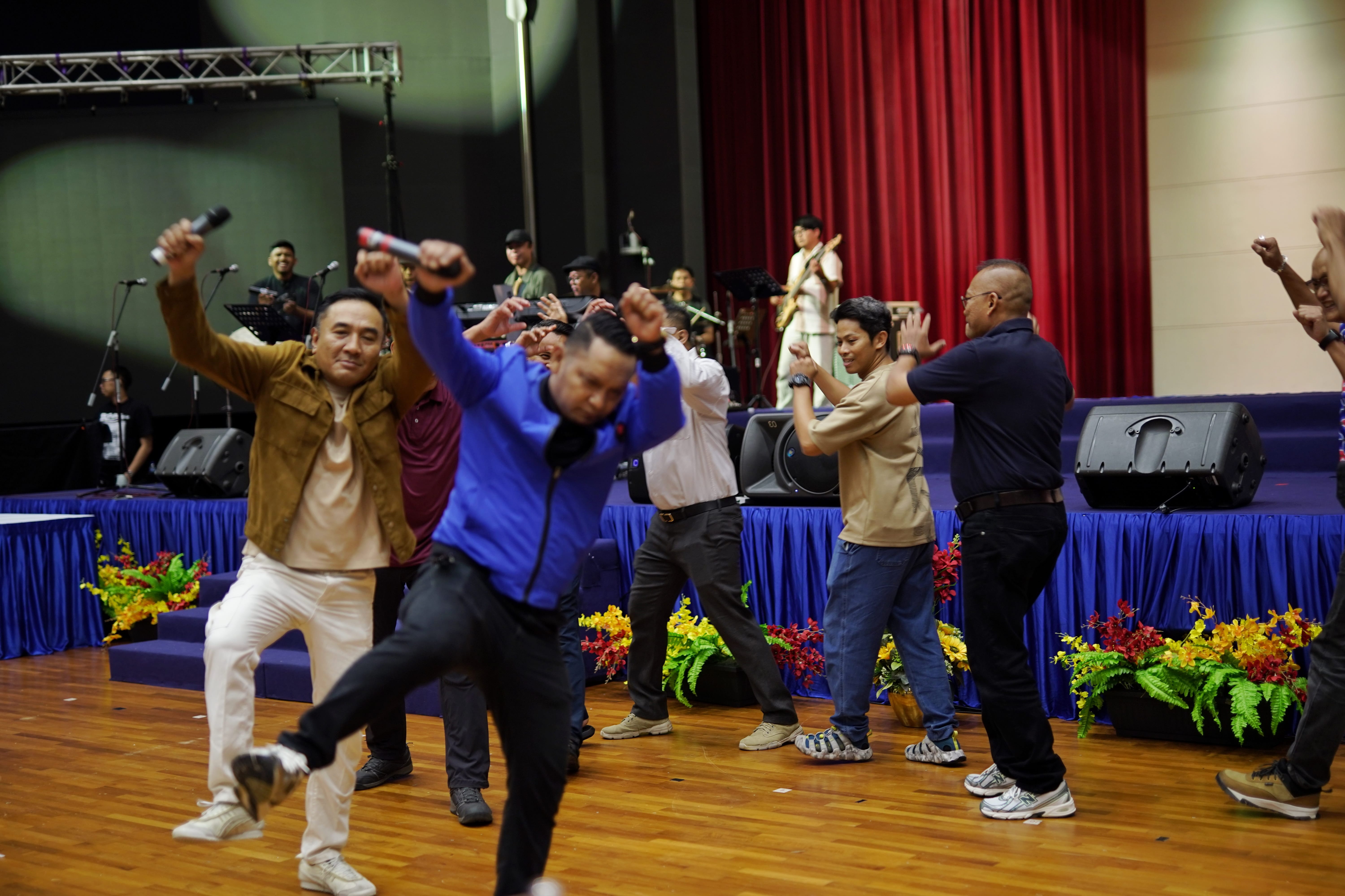Participants dance energetically as a live band performs in the background.